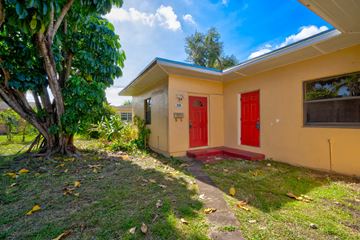 Miami apartment for rent - A small house with a red door is surrounded by greenery.