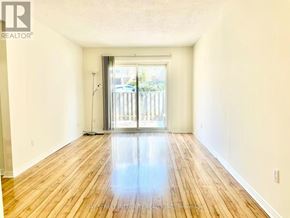 Toronto (Don Valley Village) townhouse for rent - A spacious room with wooden floors and a sliding glass door leading outside.