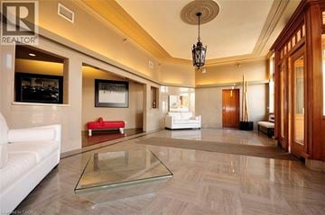 Kitchener condo for rent - A spacious living room with a glass coffee table and a red sofa.