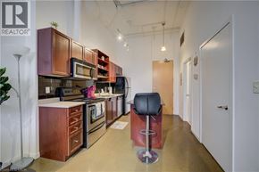 Kitchener condo for rent - A modern kitchen with a bar stool in the middle.