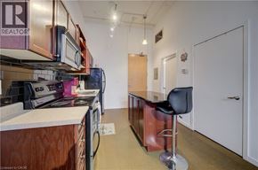 Kitchener condo for rent - A kitchen with a bar stool and a chair.