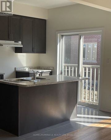 Pickering apartment for rent - A kitchen with dark brown cabinets and a counter top.