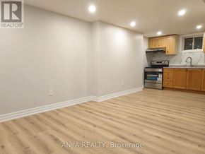 Markham (Village Green-South Unionville) apartment for rent - A room with wooden flooring and a kitchen area in the background.