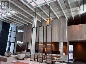 Vaughan (Vaughan Corporate Centre) condo for rent - A modern office lobby with a reception desk and chairs.