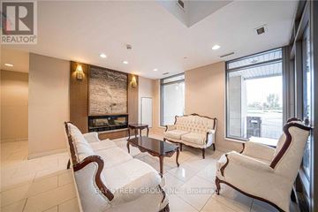 Richmond Hill (Beaver Creek Business Park) condo for rent - A living room with a fireplace and a large painting on the wall.