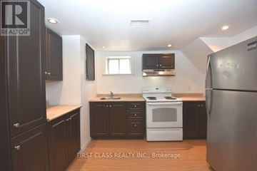 Newmarket (Bristol-London) apartment for rent - A kitchen with dark brown cabinets and a white stove top oven.