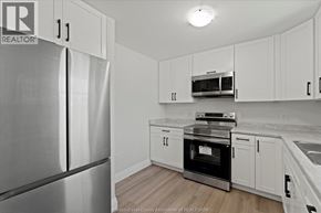 Windsor apartment for rent - A kitchen with white cabinets and a stainless steel refrigerator.
