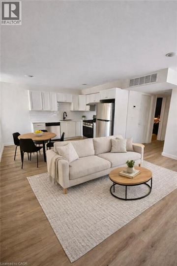 Hamilton apartment for rent - A modern living room with a white couch and a coffee table.