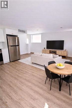 Hamilton apartment for rent - A modern living room with a television, a couch, and a dining table.