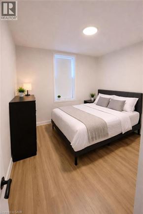 Hamilton apartment for rent - A bedroom with a bed, nightstand, and lamp.