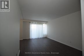 Brantford multi-family for rent - A large empty room with a window covered in white curtains.