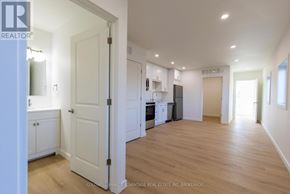 Port Colborne (Sugarloaf) multi-family for rent - A spacious kitchen with white cabinets and a white door leading to another room.