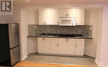 Vaughan (Vellore Village) apartment for rent - A kitchen with white cabinets and a black and white backsplash.