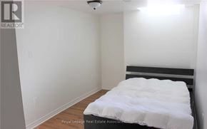 Vaughan (Vellore Village) apartment for rent - A bedroom with a bed, wooden floor, and white walls.