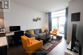 Vaughan (Beverley Glen) condo for rent - A spacious room with wooden flooring and a kitchenette in the background.