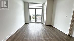 Vaughan (Beverley Glen) condo for rent - A room with a large window and wooden flooring.