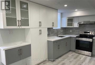 Halton Hills (Georgetown) apartment for rent - A kitchen with white cabinets and a stainless steel oven.