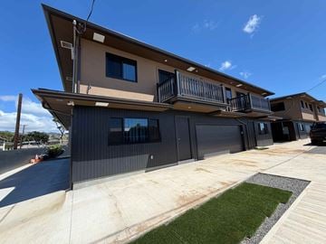 Aiea apartment for rent - A modern two-story house with a balcony on the upper floor.