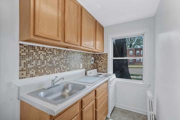 Essex apartment for rent - A kitchen with wooden cabinets and a tiled backsplash.