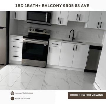 Edmonton apartment for rent - A kitchen with white cabinets and a black stove top oven.
