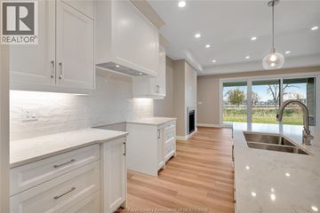 Amherstburg apartment for rent - A modern kitchen with white cabinets and a marble countertop.