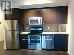 Toronto (Willowdale East) condo for rent - A kitchen with black cabinets and stainless steel appliances.