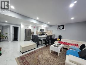 Windsor apartment for rent - A living room with a white couch, a rug, and a dining table.