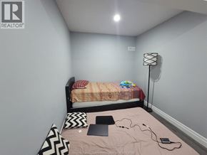 Windsor apartment for rent - A bedroom with a bed, laptop, and a lamp.