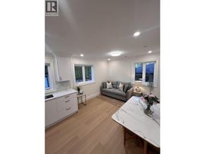 Vancouver apartment for rent - A well-lit, spacious kitchen and living room with a marble table and wooden flooring.