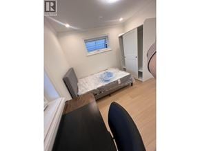 Vancouver apartment for rent - A bedroom with a bed, chair, and window.