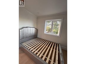 Vancouver apartment for rent - A bed with wooden slats in a room with a window.