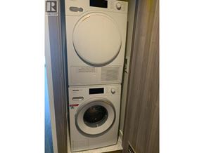 Vancouver apartment for rent - A white front loading washing machine with a black control panel.