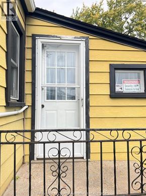Windsor apartment for rent - A yellow house with a white door and a black iron fence.