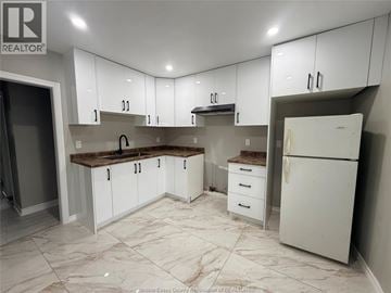 Windsor apartment for rent - A kitchen with white cabinets and a marble floor.