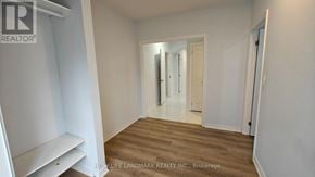 Vaughan (Vellore Village) apartment for rent - A room with wooden flooring and white walls, with a doorway leading to another room.