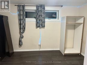 Barrie (Grove East) apartment for rent - A room with a window, curtains, and a wooden floor.