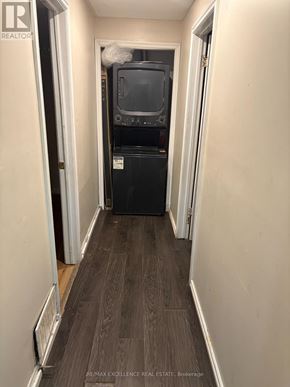 Barrie (Grove East) apartment for rent - A long, narrow hallway with a black fridge and a TV on top of it.