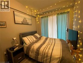 Waterloo condo for rent - A bedroom with a bed, nightstand, and a painting on the wall.