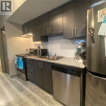 Waterloo condo for rent - A kitchen with a refrigerator, microwave, and oven.