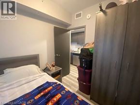 Waterloo condo for rent - A bedroom with a bed, nightstand, and a wardrobe.