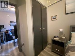 Waterloo condo for rent - A bedroom with a bed, nightstand, and a wardrobe.