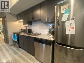 Waterloo condo for rent - A kitchen with a refrigerator covered in papers.