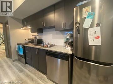 Waterloo condo for rent - A kitchen with a refrigerator covered in papers.