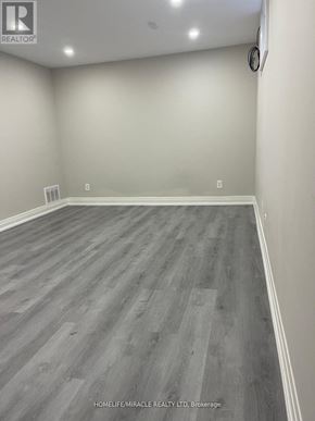 Toronto (Tam O'shanter-Sullivan) apartment for rent - A room with wooden flooring and white walls.