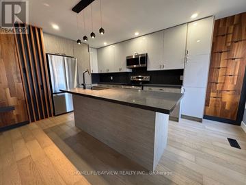 Aurora (Hills Of St Andrew) apartment for rent - A modern kitchen with wooden cabinets and a central island.