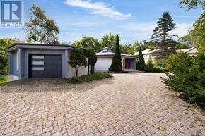 Oro-Medonte (Horseshoe Valley) apartment for rent - A house with a grey garage door is surrounded by greenery.