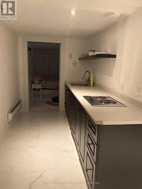 Toronto (South Parkdale) apartment for rent - A kitchen with a white counter top and a stove top oven.