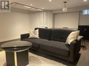 Toronto (South Parkdale) apartment for rent - A black couch with a round table in front of it.