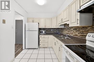 Toronto (Humbermede) condo for rent - A kitchen with a white fridge and black countertops.