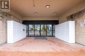 Toronto (Humbermede) condo for rent - The entrance to a building with a glass door and a brick wall.